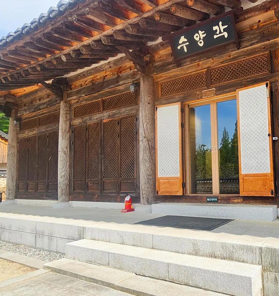 현판 «수양각»이 걸린 한옥 전시관 정면의 창살문과 나무 기둥, 앞쪽 돌계단