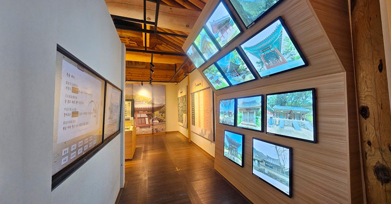 한옥 사진이 뜬 화면들이 벽에 걸린 수양각 전시 복도